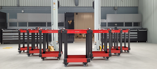Red heavy-duty mobile tool cart with multiple drawers and casters for industrial or garage use